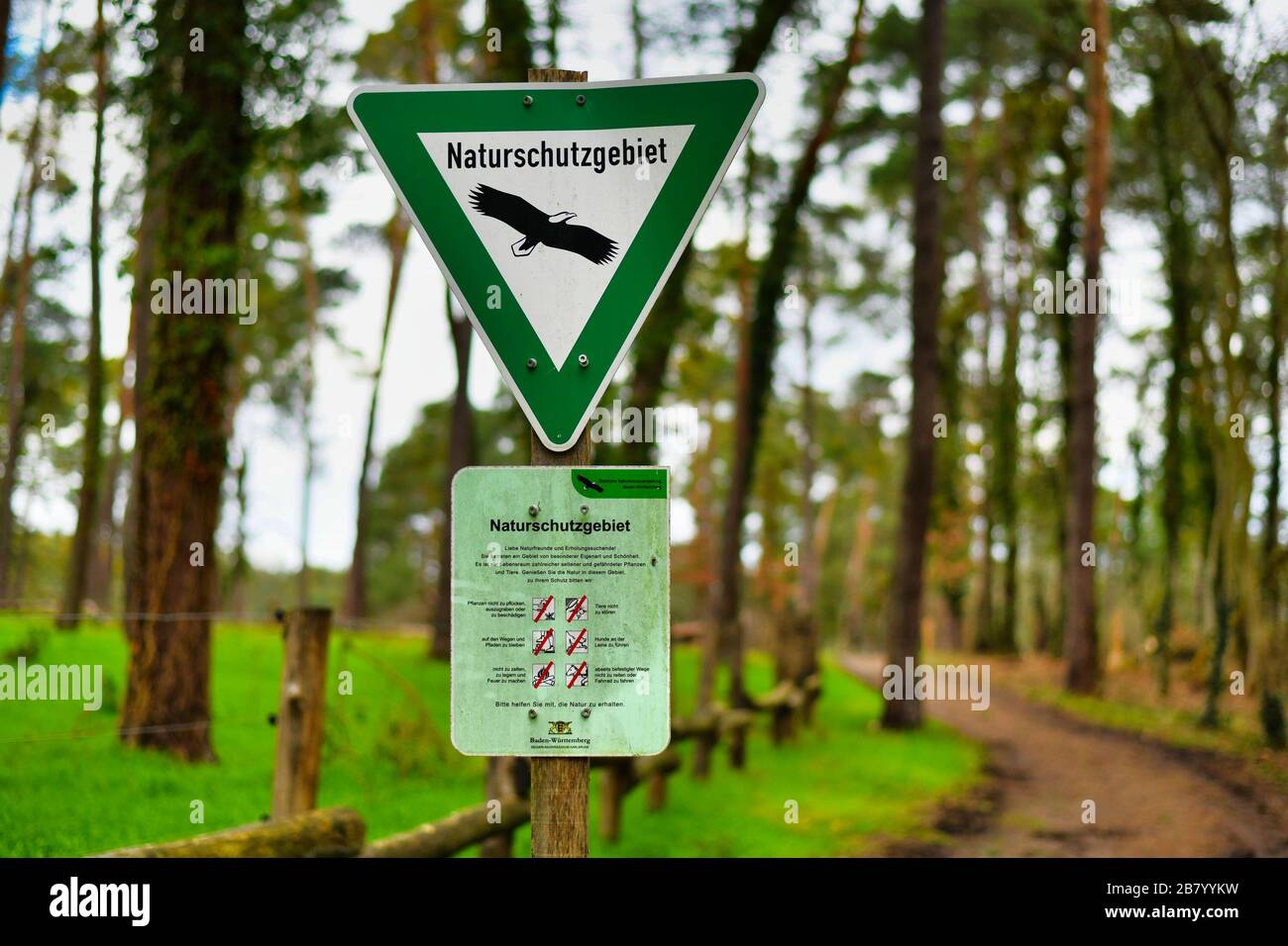 Green triangular sign with eagle and sign with behavior rules for German Nature Reserve, a category of protected area within Germany`s Feder Stock Photo